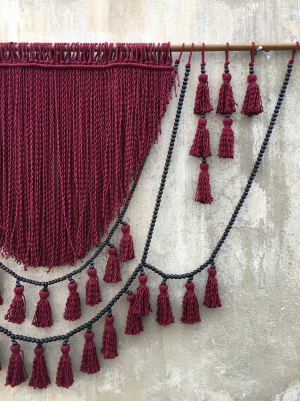 Red macrame headboard with beads