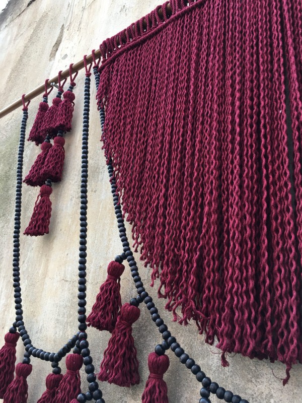 Red macrame headboard with beads